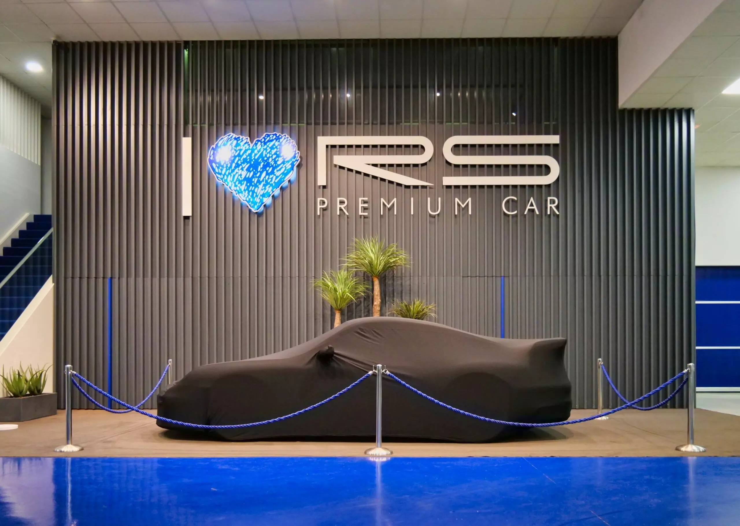 Coche de alta gama cubierto con lona negra personalizada para la entrega exclusiva en RS Premium Car