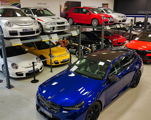 Colección de coches deportivos de lujo expuestos en plataformas elevadoras del concesionario RS Premium Car