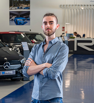Martín, miembro del equipo de RS Premium Car, posando ante la flota de coches de ocasión en las instalaciones