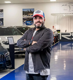 Óscar, especialista en fotografía de RS Premium Car, posando en la zona de exposición de coches deportivos